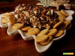 Formaggio cremoso rotolato in frutta secca e spezie
